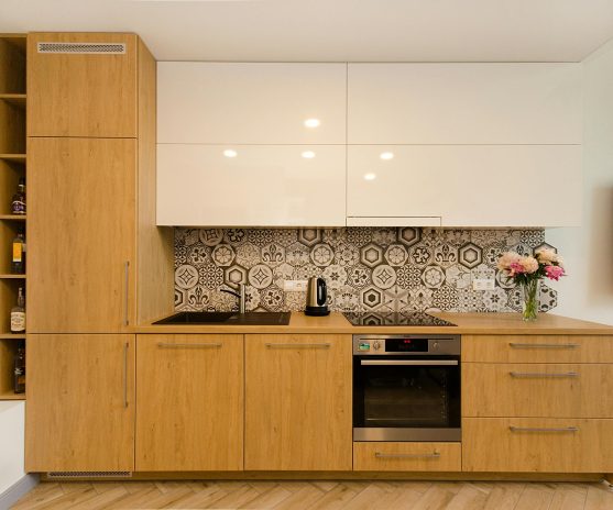 Contemporary kitchen with wooden cabinets and geometric tile backsplash.